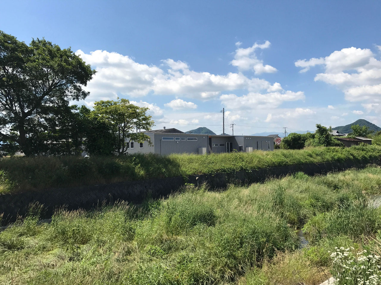 河川敷沿いに立つ平屋の家