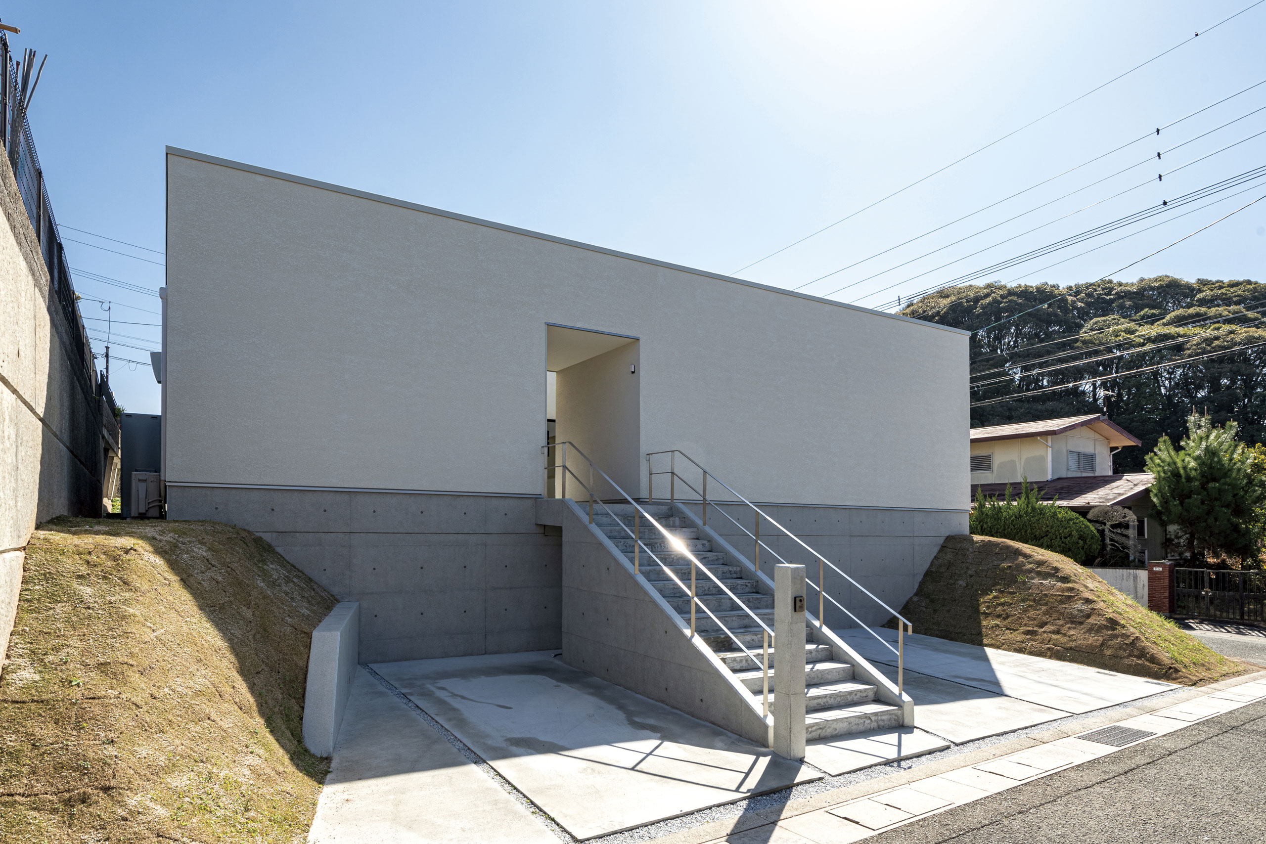 丘の上に建つ白色箱型の平屋